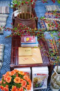 a table with flowers and books on top of it at Homestay Quản Thanh in Loung Co
