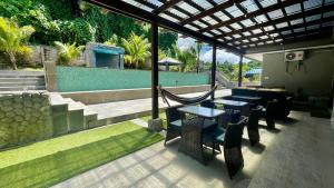 Un patio con mesas y sillas y una piscina. en Ngermid Oasis - 2 BD & 1 BA Cozy Cottage, en Koror