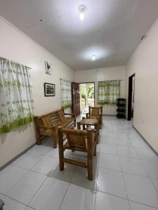 a room with wooden chairs and tables and windows at Casa Fleur in Cangalwang