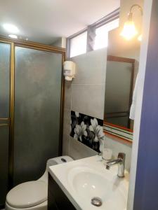 a bathroom with a toilet and a sink and a mirror at Magical house in Salento Wiht prívate jacuzzi in Salento