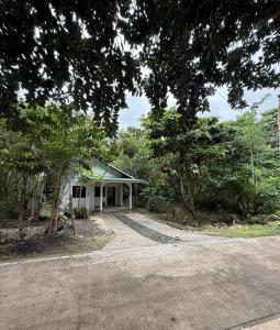 a white house with trees in front of it at Casa Fleur in Cangalwang