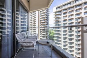 a balcony with two chairs and a table and large windows at Dominiks silent and quite Classic 1 Bedroom 47 sqm Tambuli Pool Balcony Beach Mactan up to 6 People in Lapu Lapu City