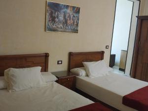 a bedroom with two beds and a picture on the wall at Ivy hotel in Alexandria