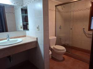 Un baño con inodoro, lavabo y ducha. en Casa en Piriápolis para ocho personas grande y luminosa, en Piriápolis 16 fotos más