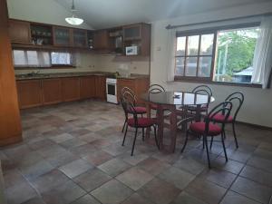 una cocina con mesa y sillas. en Casa en Piriápolis para ocho personas grande y luminosa, en Piriápolis