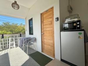 Il comprend une cuisine équipée d'un réfrigérateur et d'une table sur un balcon. dans l'établissement D sleep Home Chiangmai, à Chiang Mai