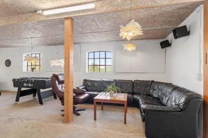 a living room with a leather couch and a table at FY285-Faaborg-Egsgyden-35 in Fåborg