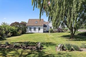 a white house with a tree in a yard at FY285-Faaborg-Egsgyden-35 in Fåborg