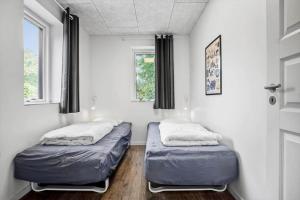 two beds in a room with two windows at FY258-Ebberup-Hegningen-5 in Ebberup