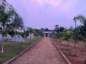 a dirt path leading to a building with trees at Holidaypark in Araku