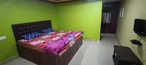 a bedroom with a bed in a room with green walls at Holidaypark in Araku