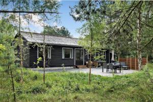 a log cabin in the woods with tables and chairs at FY358-Martofte-Sandvejen-3 in Martofte