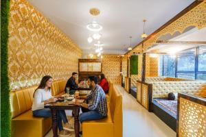 a group of people sitting at a table in a restaurant at FabHotel Grand Broholic - Nr Hitech City in Hyderabad