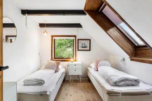a attic room with two beds and a window at FY297-Faaborg-Ostergyden-37 in Faaborg