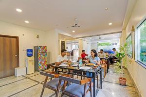 ハイデラバードにあるFabHotel Namaha Suites - Nr Hyderabad International Airport, Shamshabadのレストランのテーブルに座っている人々のグループ