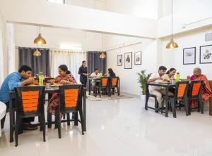 a group of people sitting at tables in a restaurant at FabHotel Majestic Luxurious - Nr Rajaram Bhiku Pathare Stadium in Pune