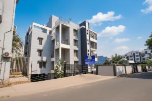 a white building with a blue sign in front of it at FabHotel Majestic Luxurious - Nr Rajaram Bhiku Pathare Stadium in Pune