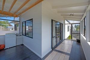 a living room with white walls and windows at Sparkling 3-bedroom home with fireplace and views in National Park