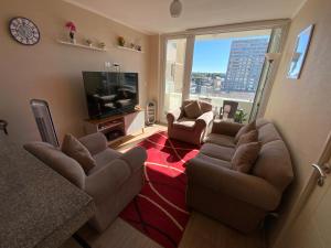 a living room with a couch and chairs and a television at Arriendo 1 Departamento Diario Amoblado en Edificio Pleno Centro de Osorno Full Eléctrico y Estacionamiento Techado, Comodidad, Moderno y Seguridad in Osorno