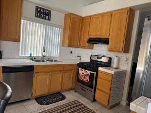 a kitchen with wooden cabinets and a stove top oven at Blue River Oasis in Bullhead City