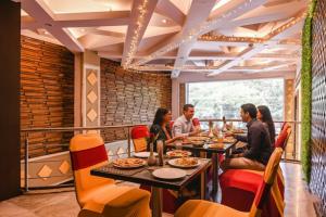 a group of people sitting at tables in a restaurant at FabHotel Shivani International in Rānchī