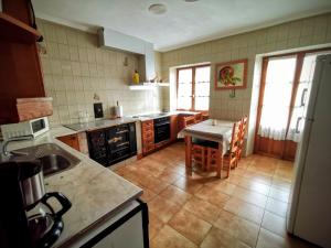 a kitchen with a sink and a table with chairs at GURE TXOKO Casa Rural in Odériz +31 photos