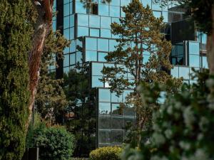 un edificio di vetro con un albero di fronte di Mercure Villa Romanazzi Carducci Bari a Bari
