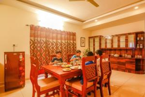 ハイデラバードにあるVia Direct Checkin - Nr Hitech Cityのダイニングルームのテーブルに座っている3人の子供