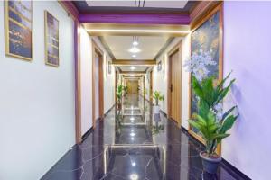 a hallway with potted plants in a building at FabHotel Bliss in Ahmedabad