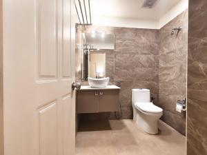 een badkamer met een toilet, een wastafel en een spiegel bij Proximus - Boutique Hotel Apartments in Bangalore +72 foto's