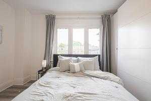 een slaapkamer met een bed met witte lakens en een raam bij Cozy & Comfy house near Subway in Toronto