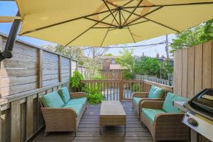een terras met stoelen en een parasol bij Cozy & Comfy house near Subway in Toronto