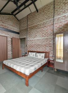 a bedroom with a bed in a brick wall at ZERO9 farmPAD - Private Eco Retreat, Karjat in Karjat