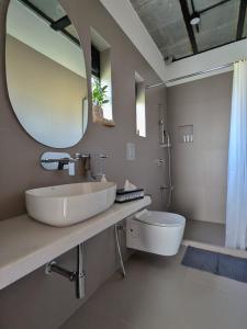 a bathroom with a sink and a mirror and a toilet at ZERO9 farmPAD - Private Eco Retreat, Karjat in Karjat