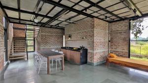 a kitchen with brick walls and a table and a bench at ZERO9 farmPAD - Private Eco Retreat, Karjat in Karjat +7 photos