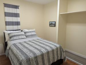 a bedroom with a bed with a striped blanket at 347 Des Meurons Street Unit A and Unit B in Bélanger