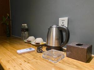 a tea kettle and a box on a wooden table at Hotel Mutiara Kota Tua in Jakarta +36 photos