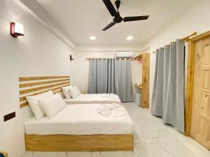 a bedroom with two beds and a ceiling fan at Thila Sky View in Thoddoo