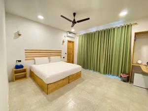 a bedroom with a bed and a green curtain at Thila Sky View in Thoddoo