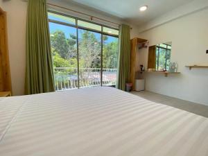 a bedroom with a large bed and a large window at Thila Sky View in Thoddoo