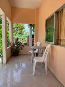 a patio with two chairs and a table and a window at Habitacion Pauvemar en Coveñas in Coveñas