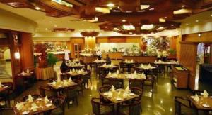 Kampong KiulapにあるThe Rizqun International Hotelの部屋にテーブルと椅子があるレストラン