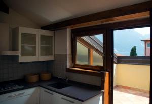リーヴァ・デル・ガルダにあるAppartamento i Sentieri 23の窓とシンク付きのキッチンが備わります。