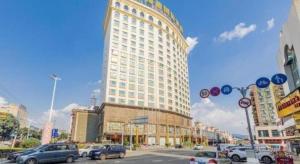 東莞市にあるRegency Hotelの車が駐車されている街路沿いの大きな建物