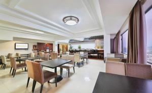 桂林市にあるTelecom Hotel Guilinのテーブルと椅子のあるダイニングルームとレストラン