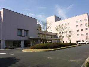 福知山市にあるHotel Royal Hill Fukuchiyama and Spaの正面に道路がある大きな白い建物