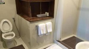 a bathroom with a toilet and a shower with towels at Mango Valley Hotel in Olongapo +203 photos