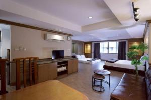 a living room with a couch and a bed and a table at Alameda Suites Hotel in Bangkok