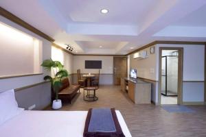 a hotel room with a bed and a desk at Alameda Suites Hotel in Bangkok