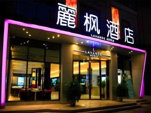 a building with a lit up sign in front of it at Lavande Hotel Yantai Train Station Branch in Yantai